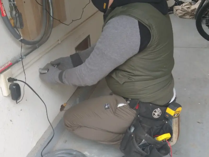 Electrician performing outlet wiring in a Kemp Mill garage